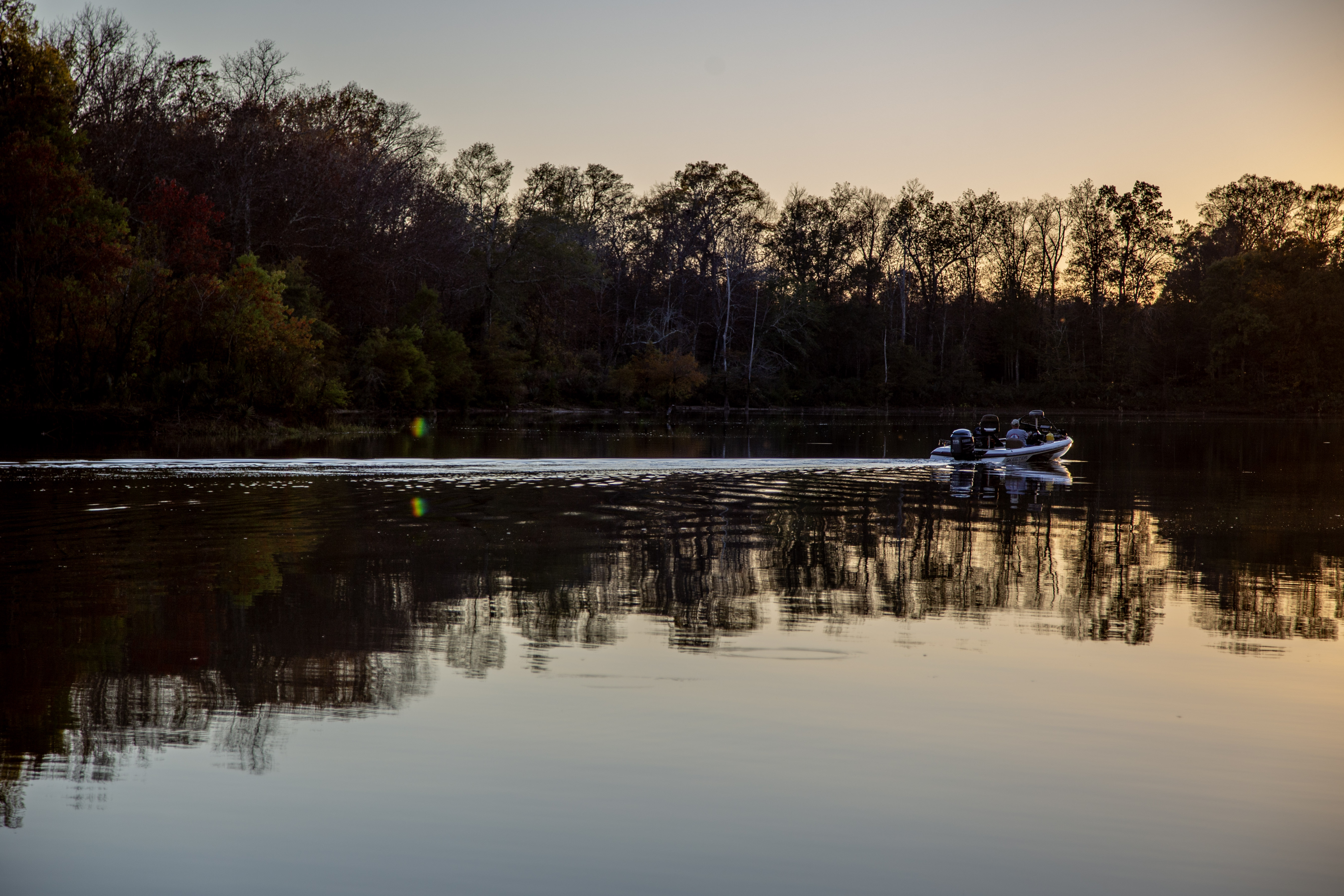 A motorboat on a lake at sunset